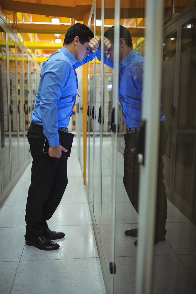 Technician getting stressed over server maintenance in server room